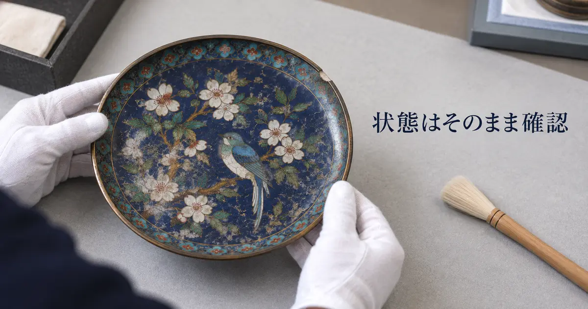 七宝焼の皿の表面状態を手袋で確認する様子
